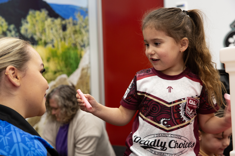 A disability worker with a young girl wearing a Deadly Choices shirt, representing disability support for Mob.
